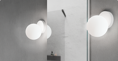 Moderne ronde wandlamp weerspiegeld in een minimalistische badkamerspiegel.